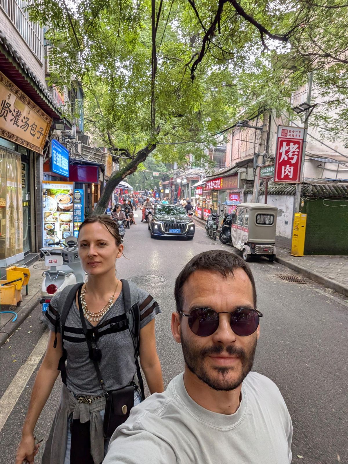 Selfie dans la rue 大莲花池街, enseignes de cantine, panneau Xi'an tourism, scooter garé