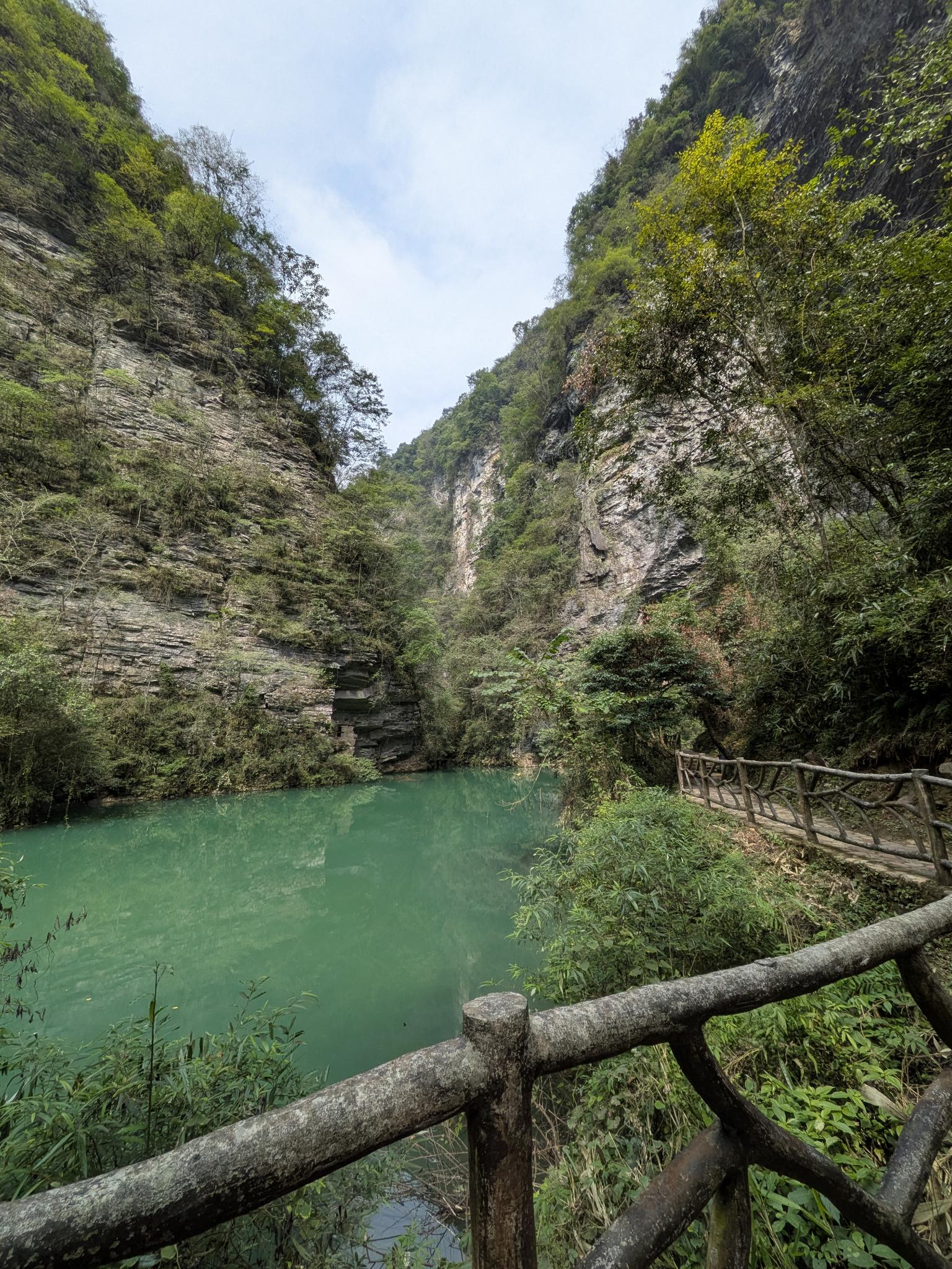 La piscine turquoise au fond de la gorge, ses parois calcaires et son garde-fou en bois