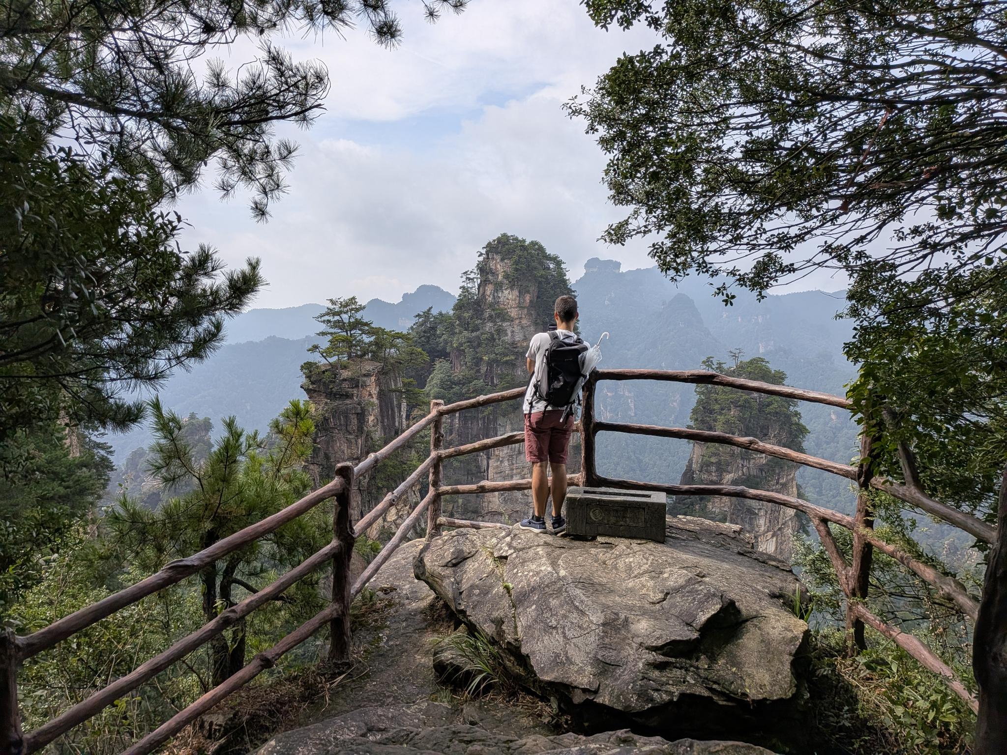 Tristan sur la roche du belvédère, son parapluie dans le sac