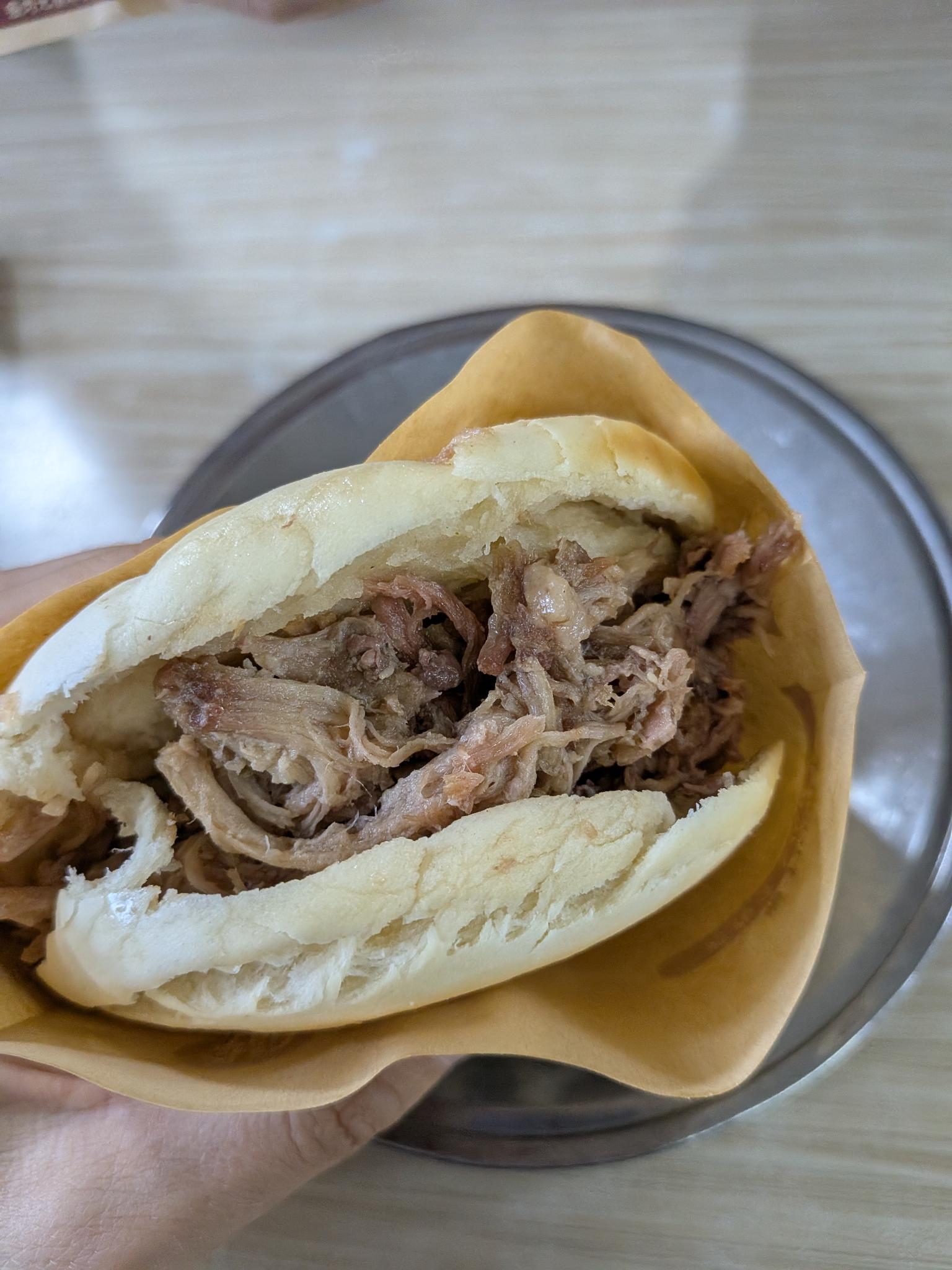 Le roujiamo en main, pain blanc fendu garni de viande laquée hachée sur son plat d'aluminium