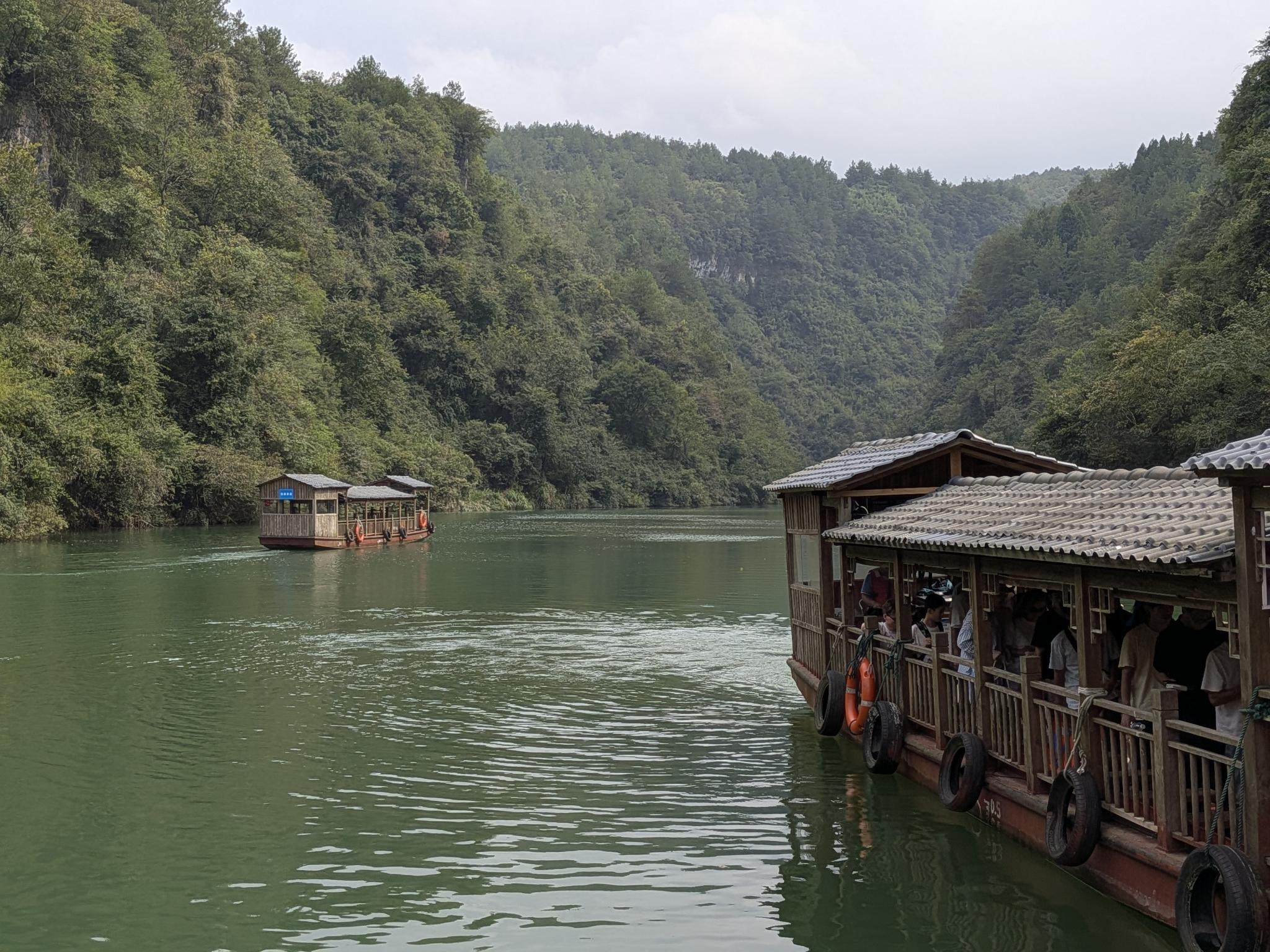 Les barques à toit de tuiles sur la rivière, leurs pneus à coussins et leurs passagers
