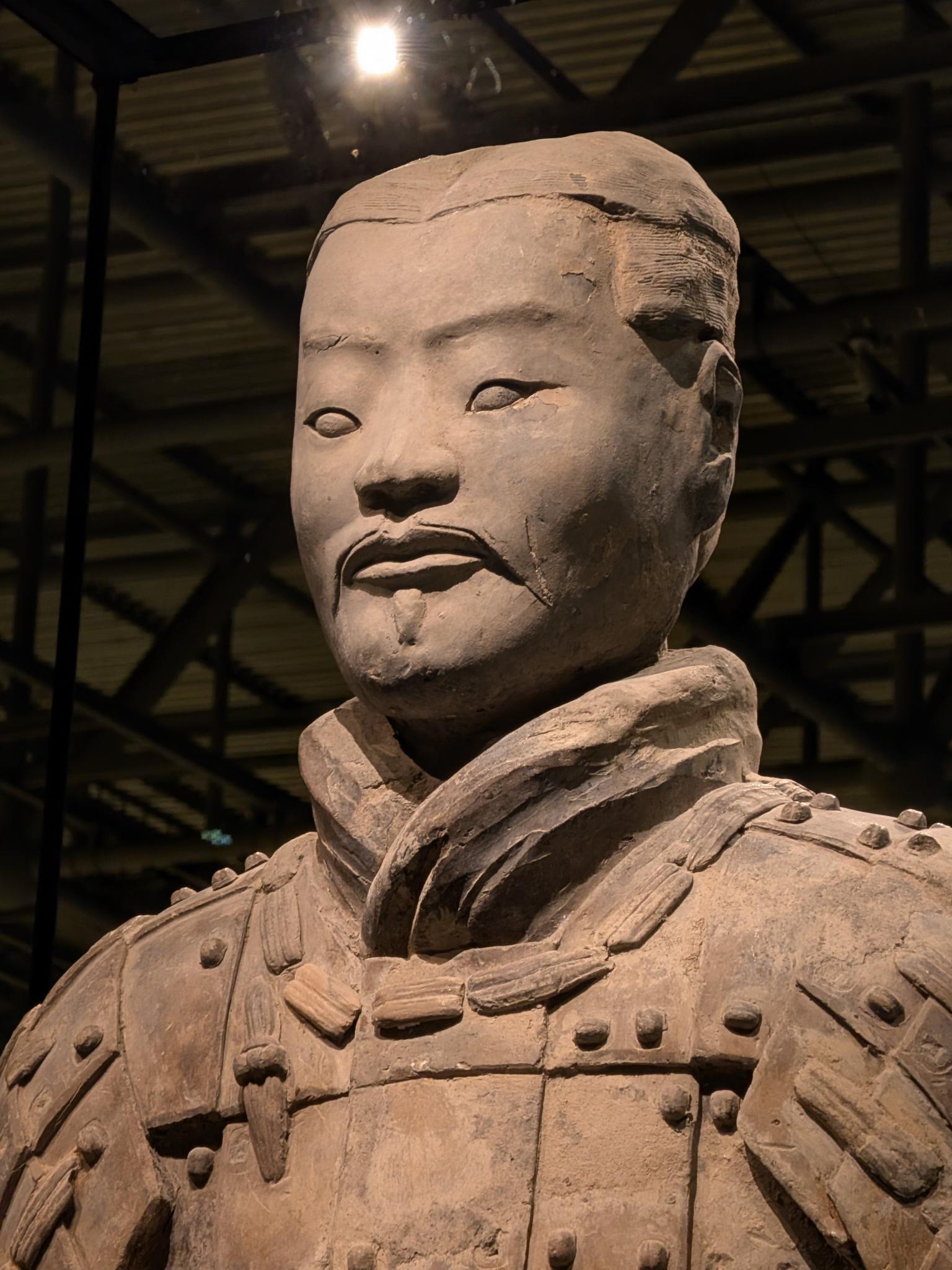 Portrait d'un guerrier sous projecteur, armure à écailles rivetées et col noué