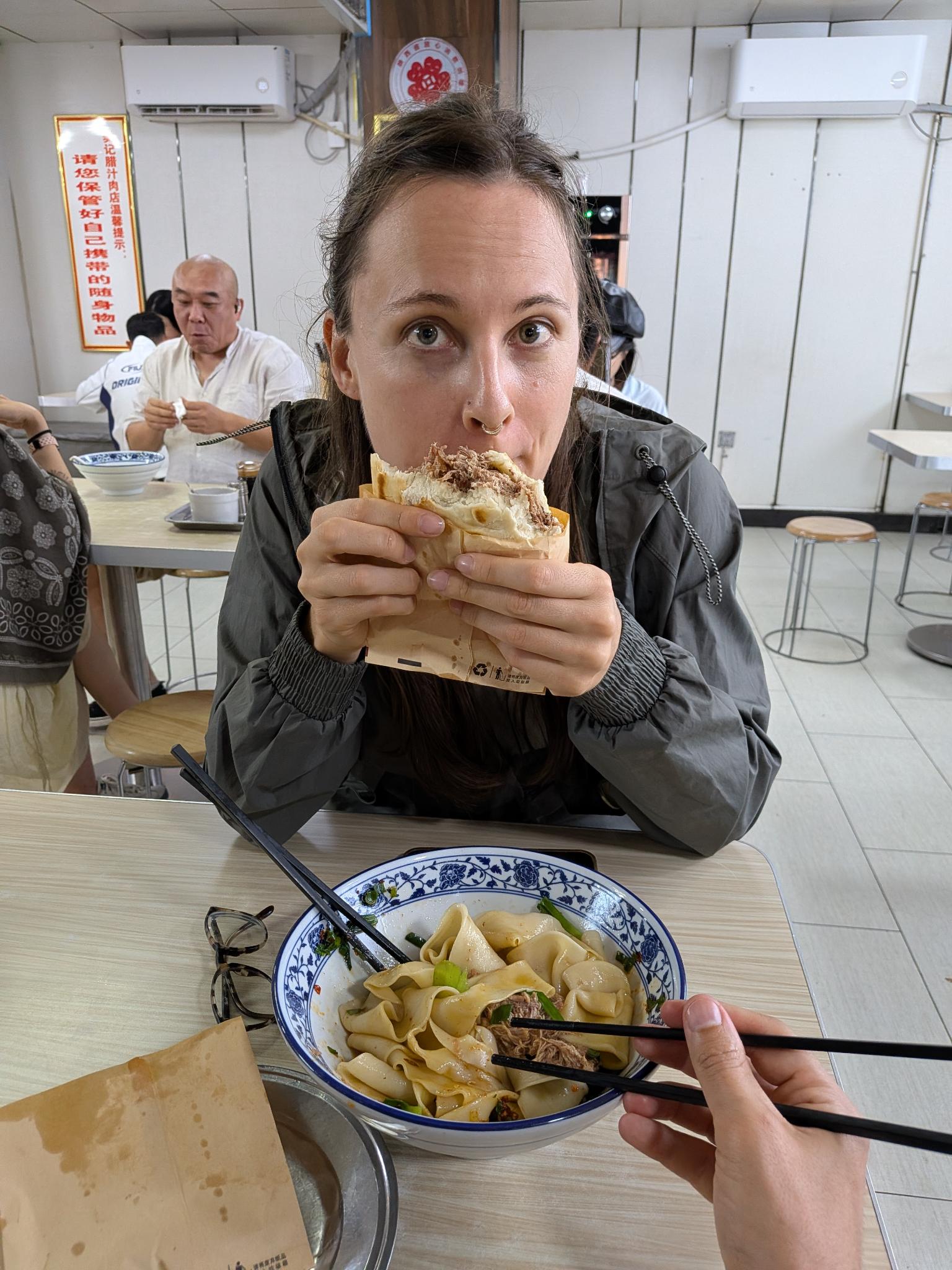 La table du Fanji : roujiamo en papier marron et bol de nouilles larges à la viande