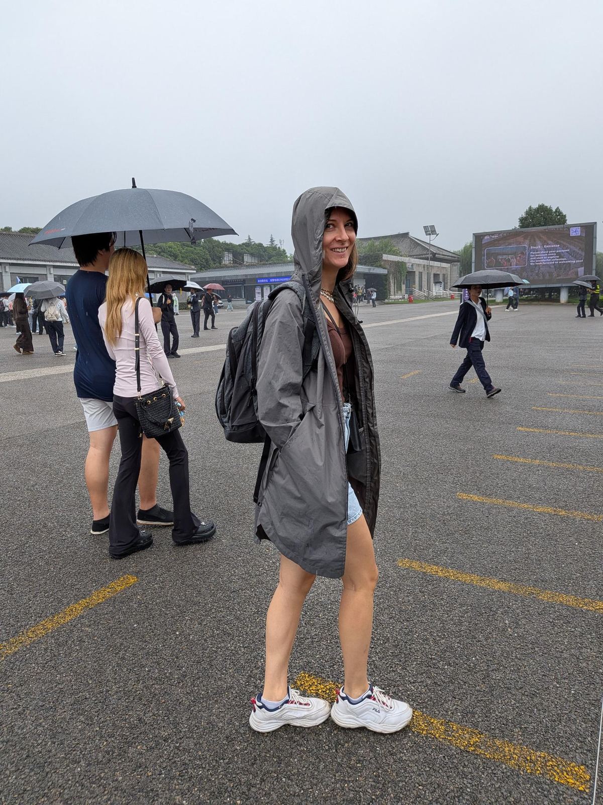 Marion en imperméable devant l'enseigne d'entrée du musée : passer le passeport pour entrer