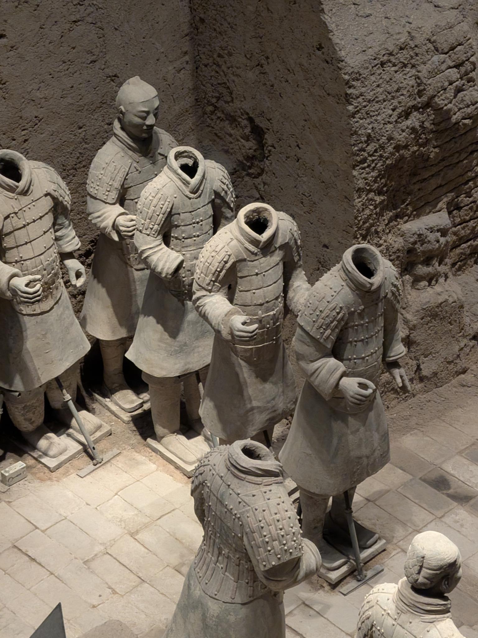 Autre rangée de guerriers, plusieurs sans tête, un visage intact en arrière-plan