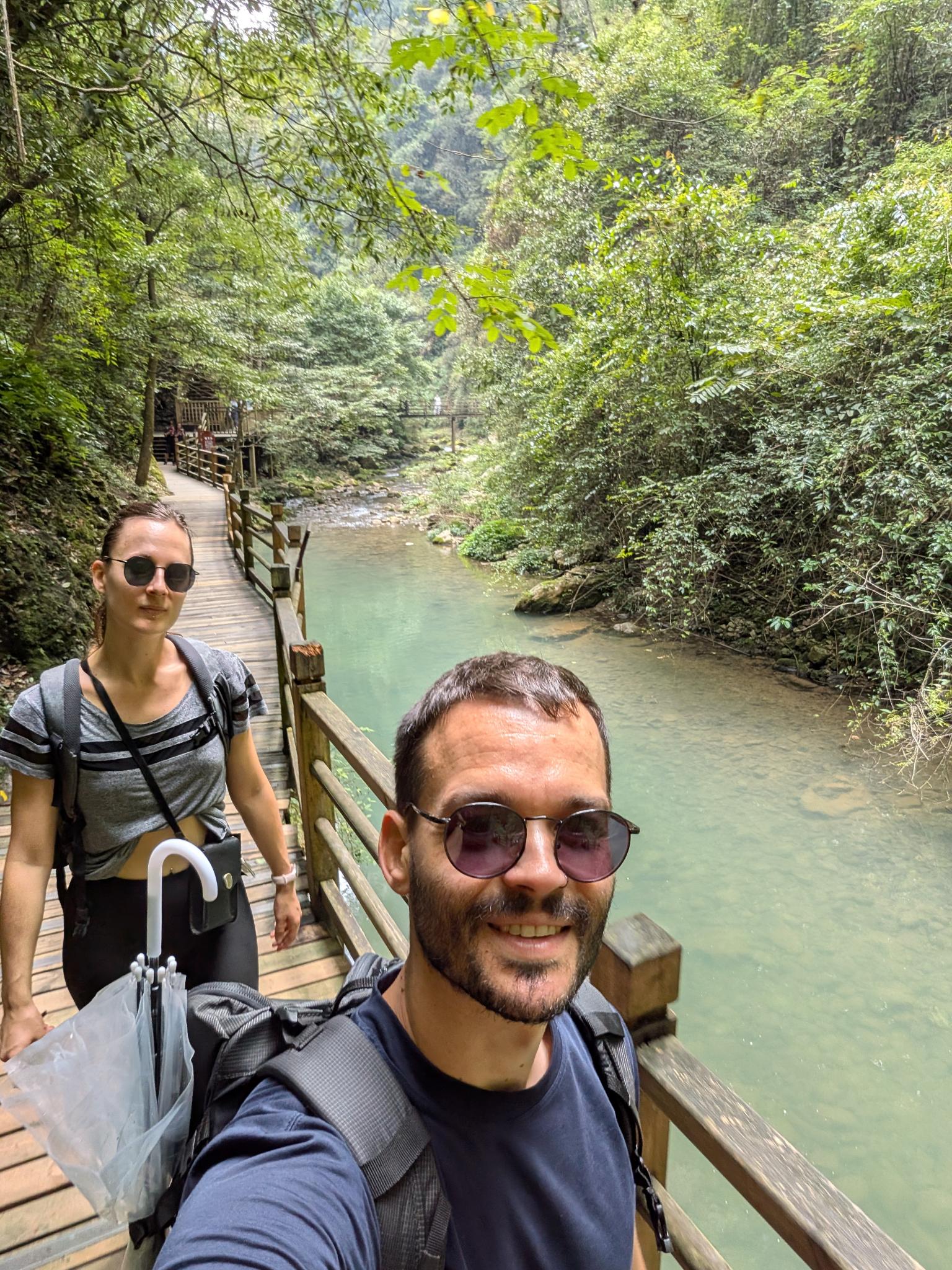 Notre selfie sur la passerelle, la rivière en bas et son dôme de verdure