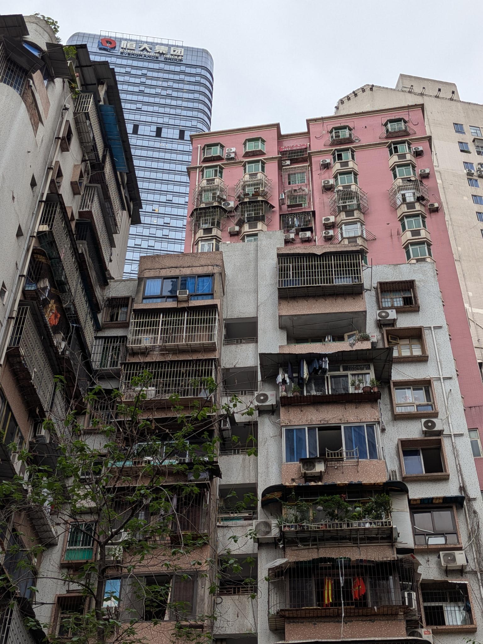 Le vieil immeuble et la tour de verre Evergrande derrière