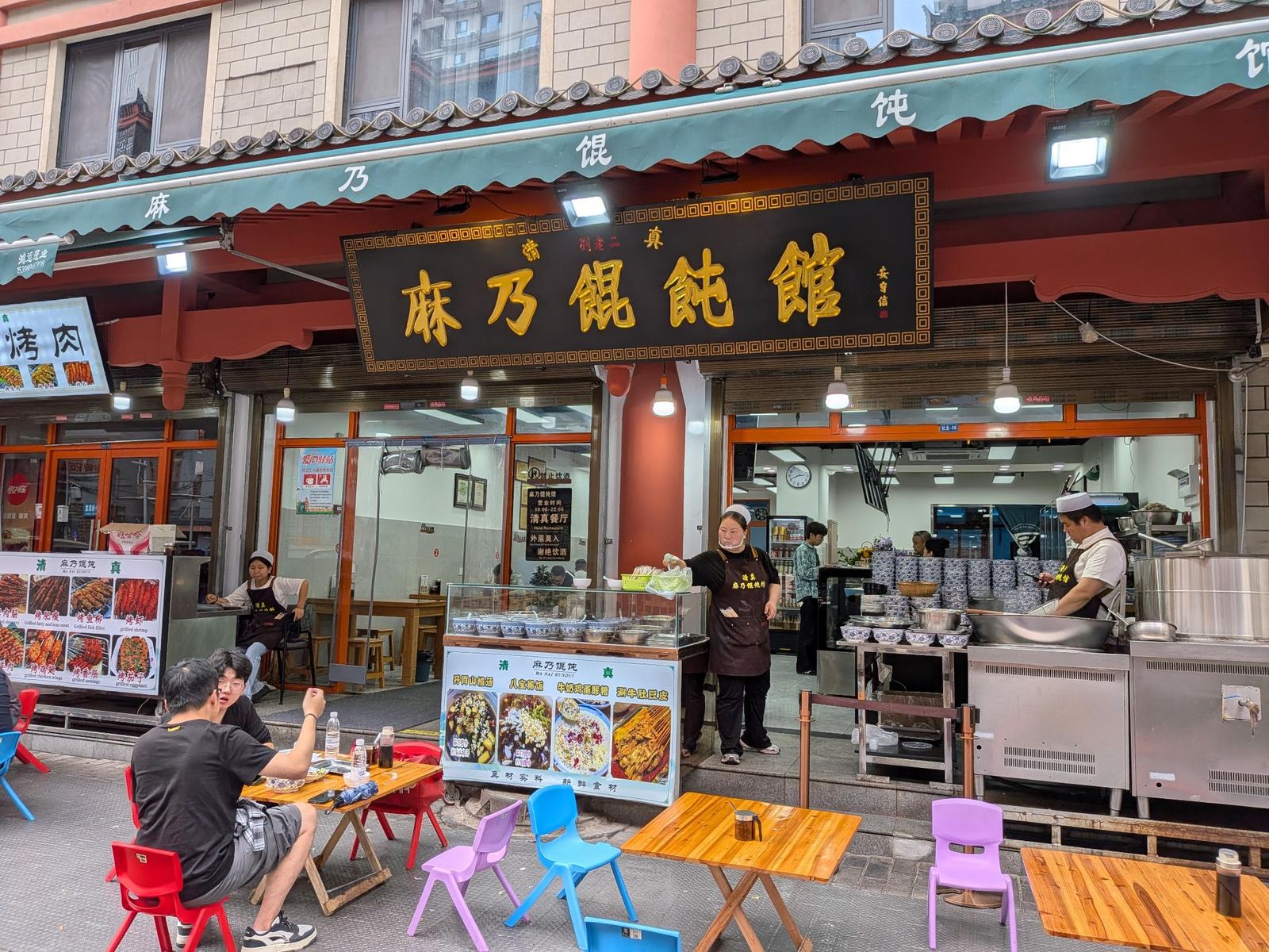 Enseigne noire 麻乃饃饃館 et auvent turquoise 麻乃馄饨, menu halal 10h-22h, comptoir inox et bol bleu et blanc