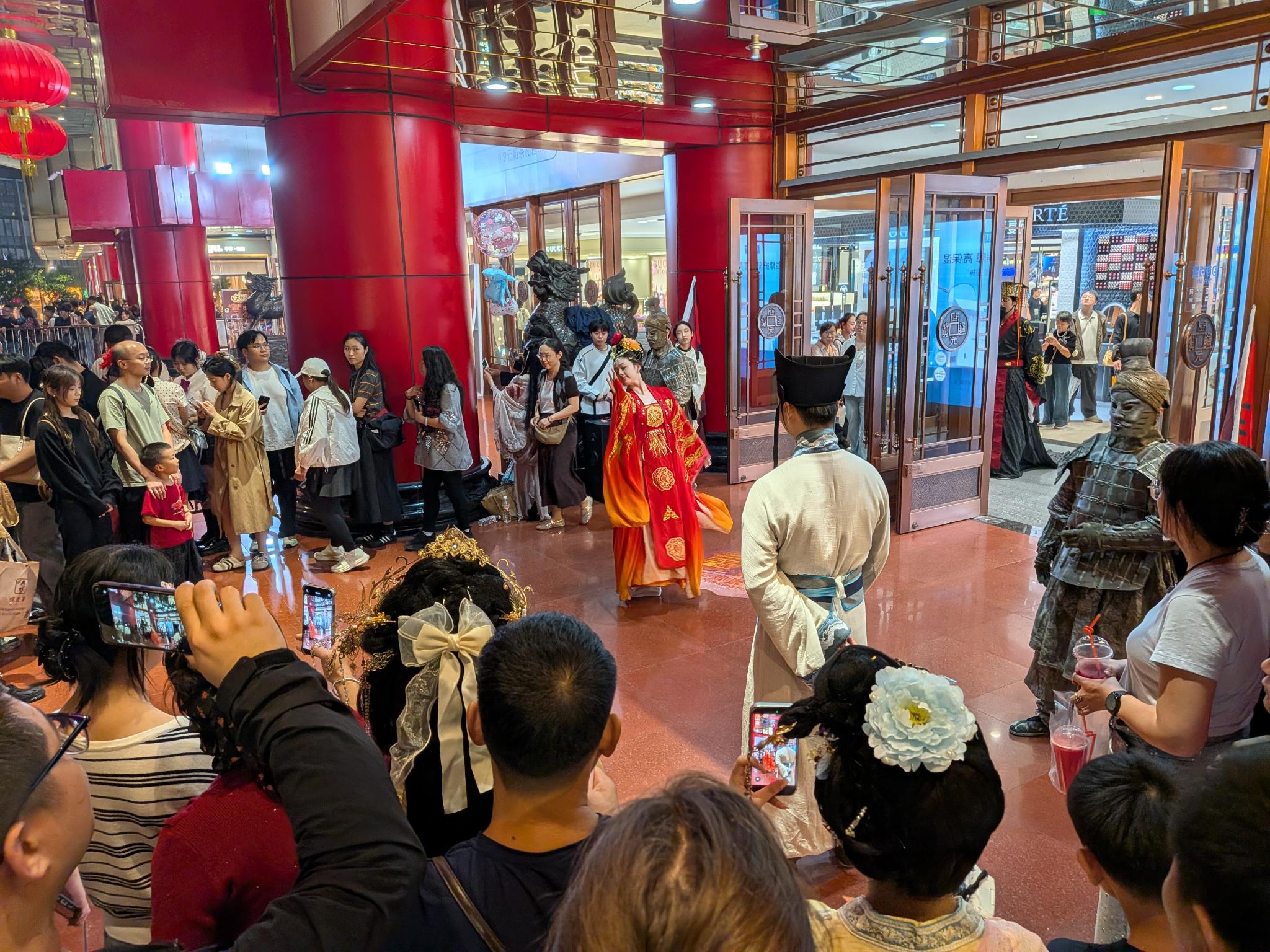 Dans le hall du mall, défilé en costumes Tang et guerriers de terre cuite devant la foule