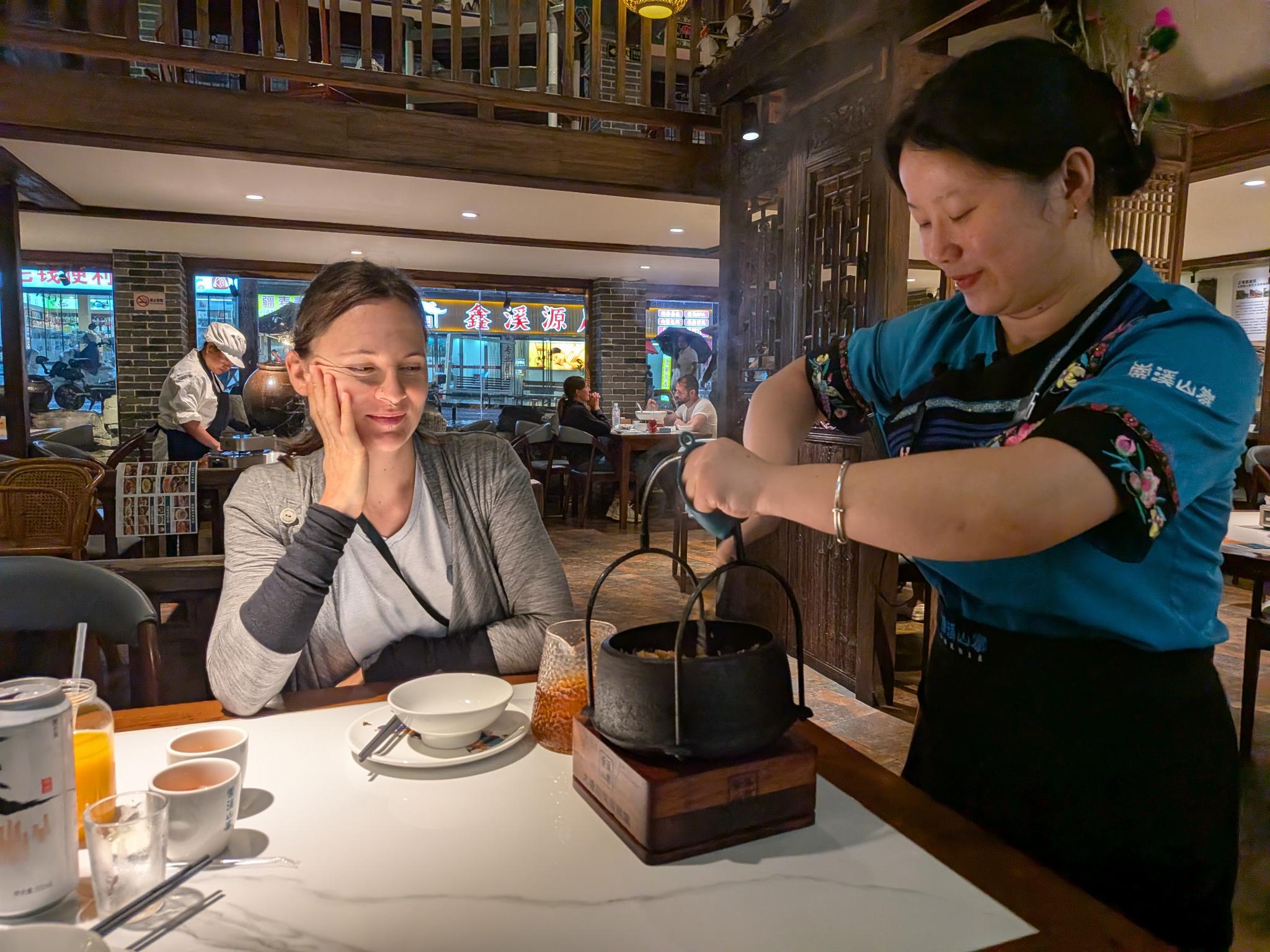 La serveuse qui remplit la marmite en fer