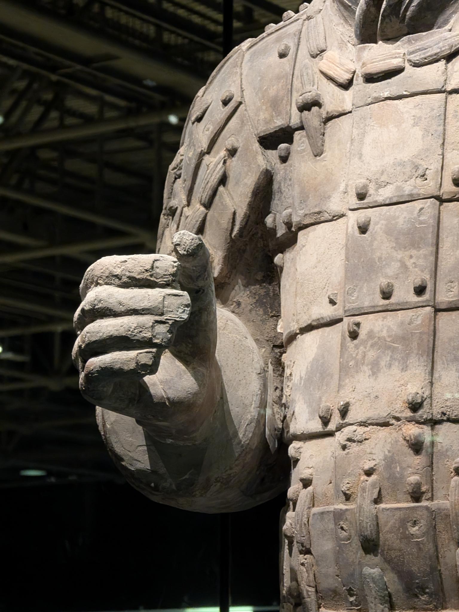 Torse et main poing d'un guerrier, armure en plaques rivetées et sangle nouée sur la poitrine