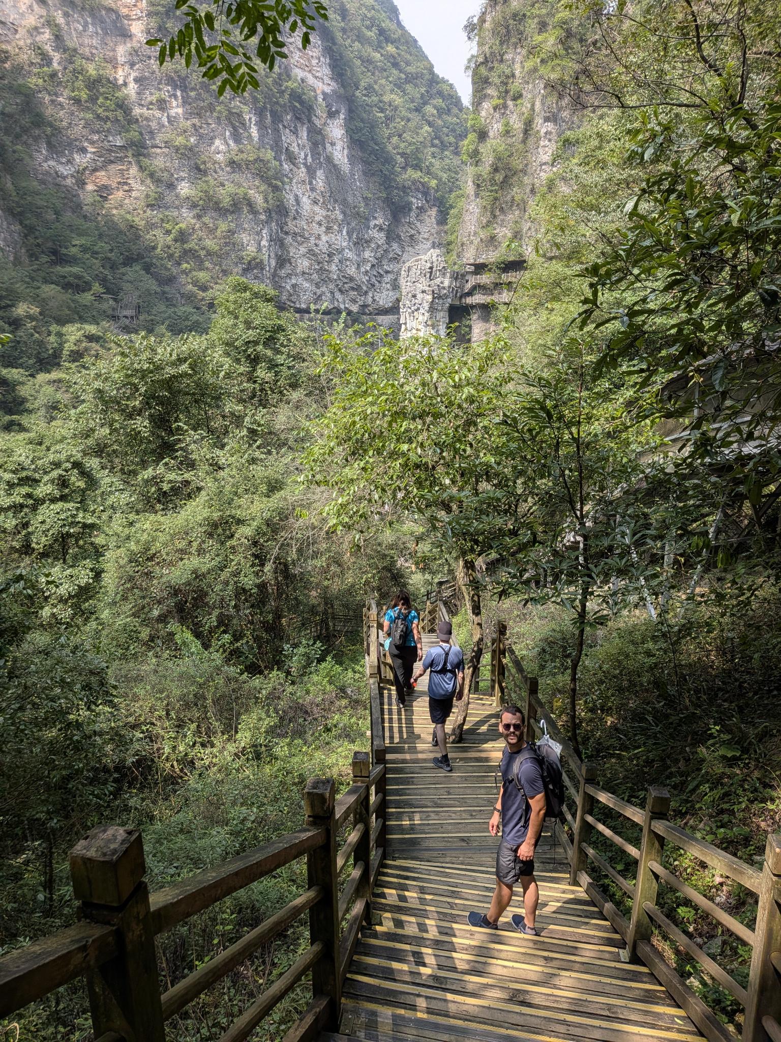 Le sentier qui descend dans la gorge, ses trois marcheurs et ses parois calcaires
