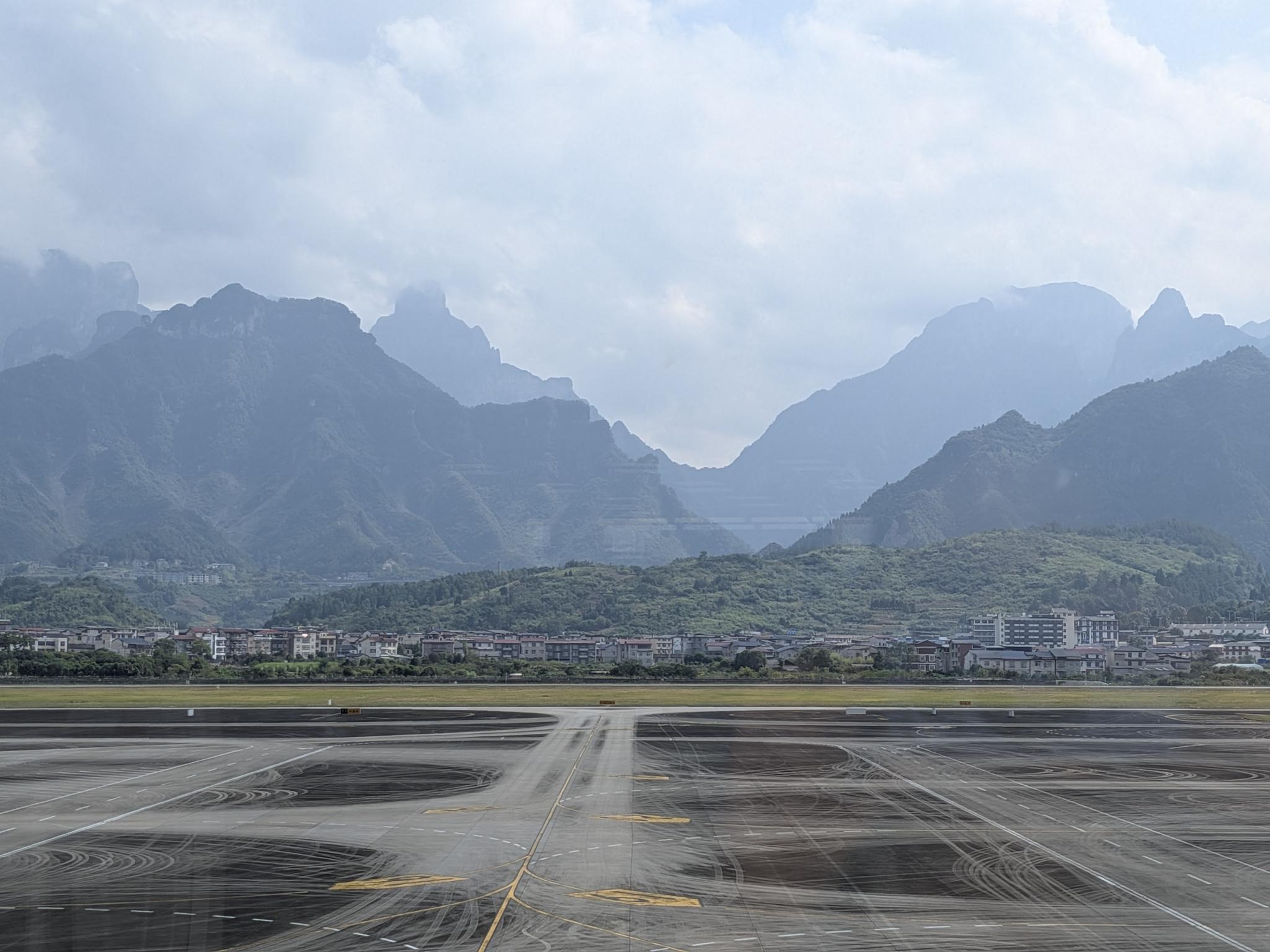 Vue de l'aéroport de Hehua : la piste mouillée, les montagnes karst en arrière-plan