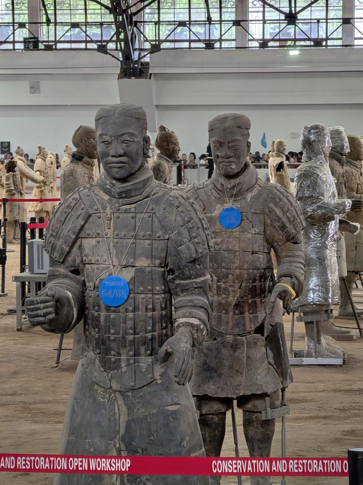 Deux guerriers avec étiquettes bleues 54/55 et 16, ruban rouge CONSERVATION AND RESTORATION OPEN WORKSHOP