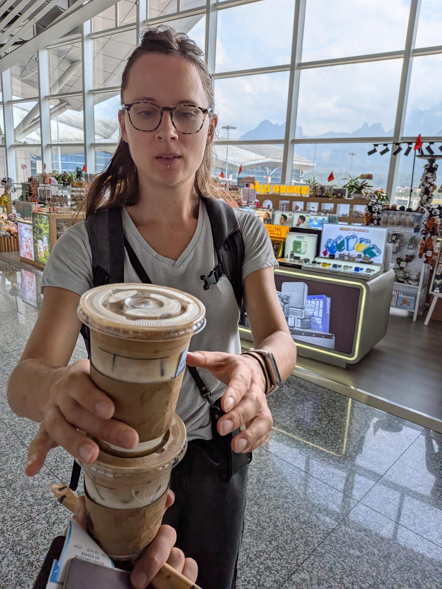 Deux cafés glacés tenus devant la caméra dans le hall de l'aéroport