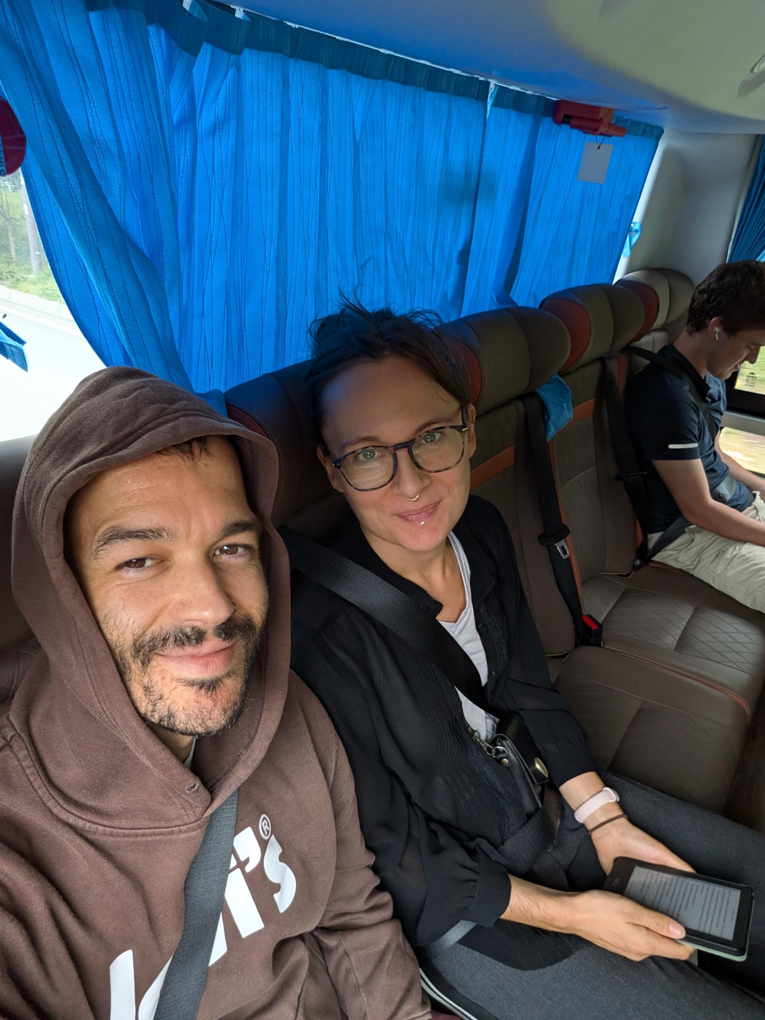 À deux devant, le Kindle dans ses mains, dans le minibus