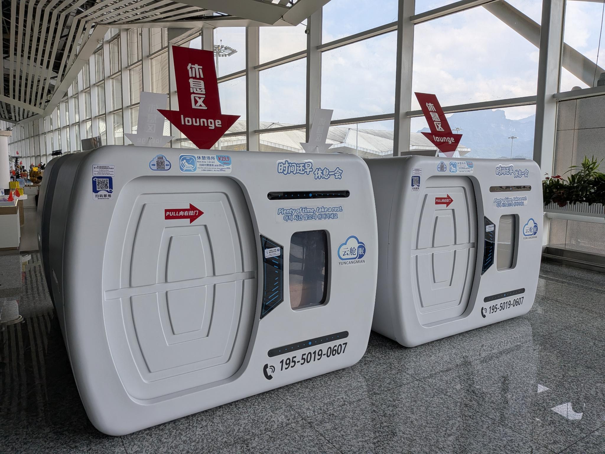 Deux capsules de sommeil Yuncangmian blanches dans le hall de l'aéroport, tarifé 19,9 ¥ les 30 minutes