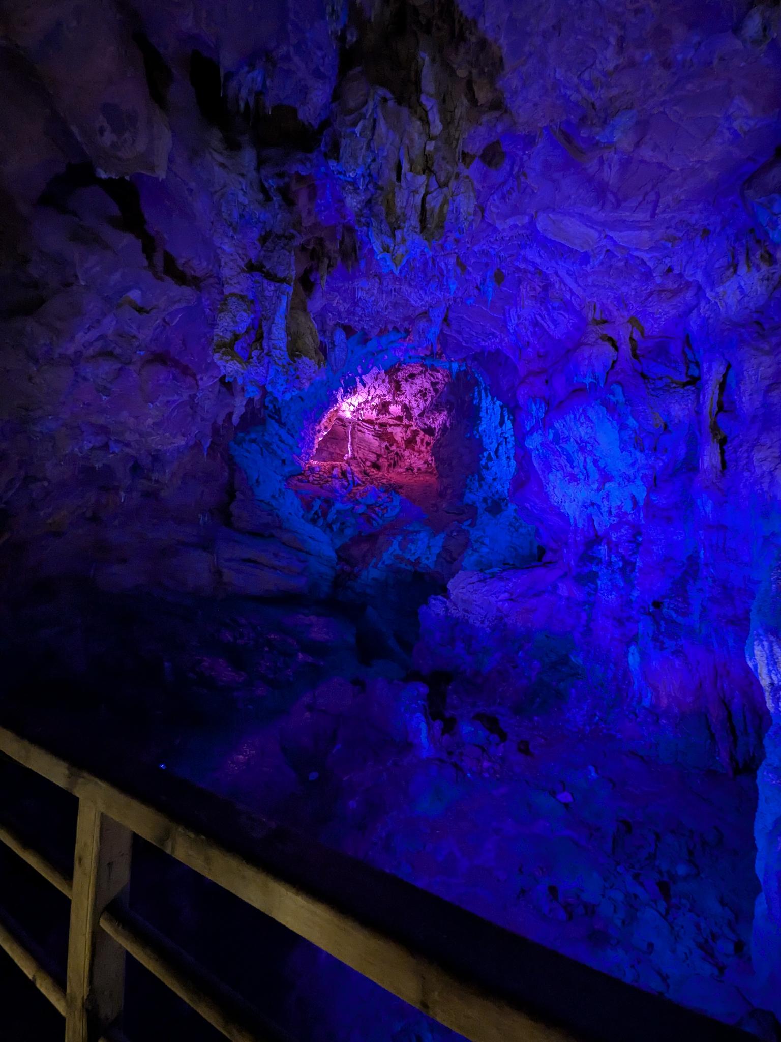 L'intérieur de la grotte, ses rochers sous un éclairage bleu et violet