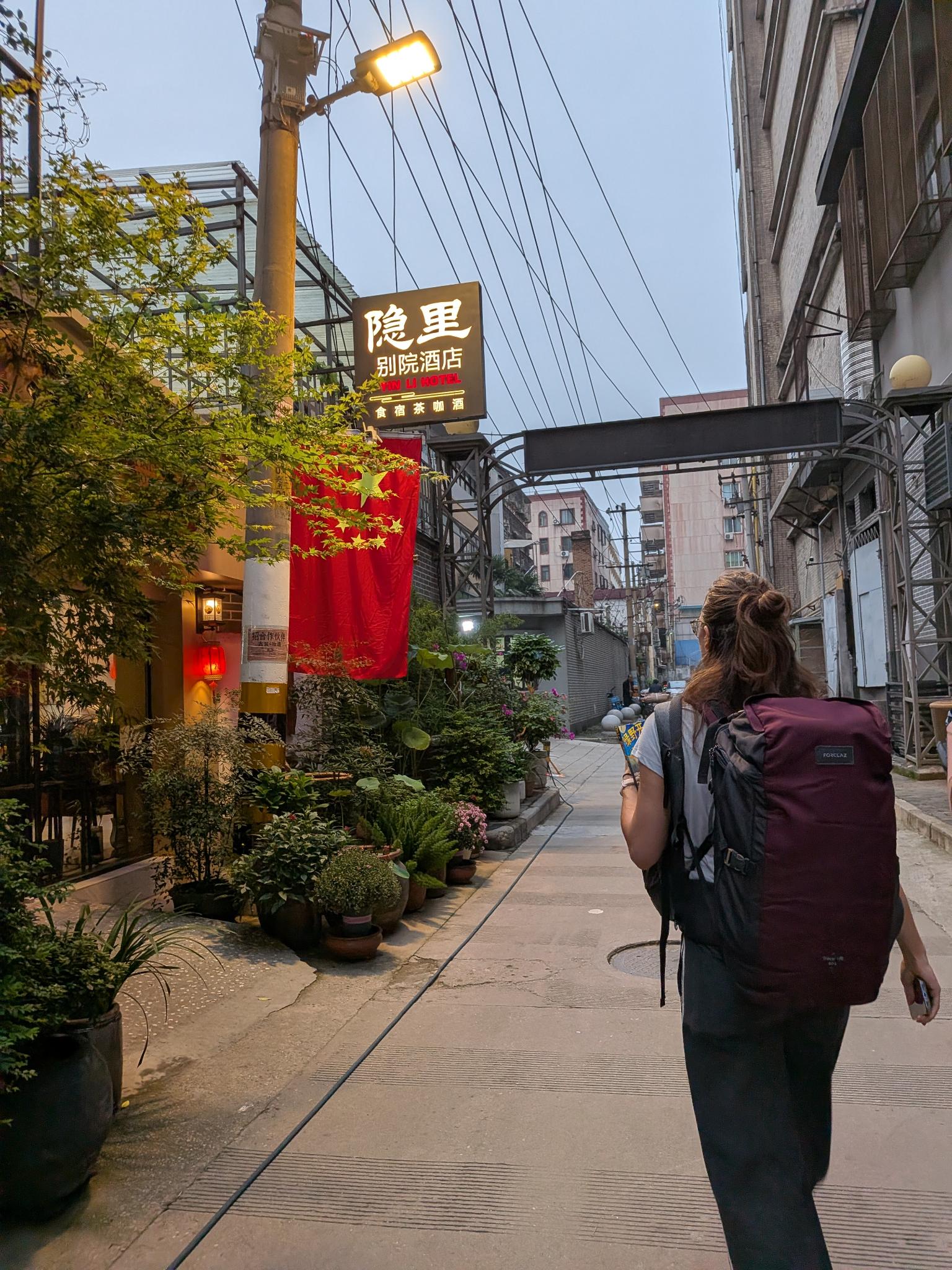La rue de l'hôtel au crépuscule, enseigne Yin Li 别院酒店 食宿茶咖酒 et drapeau rouge