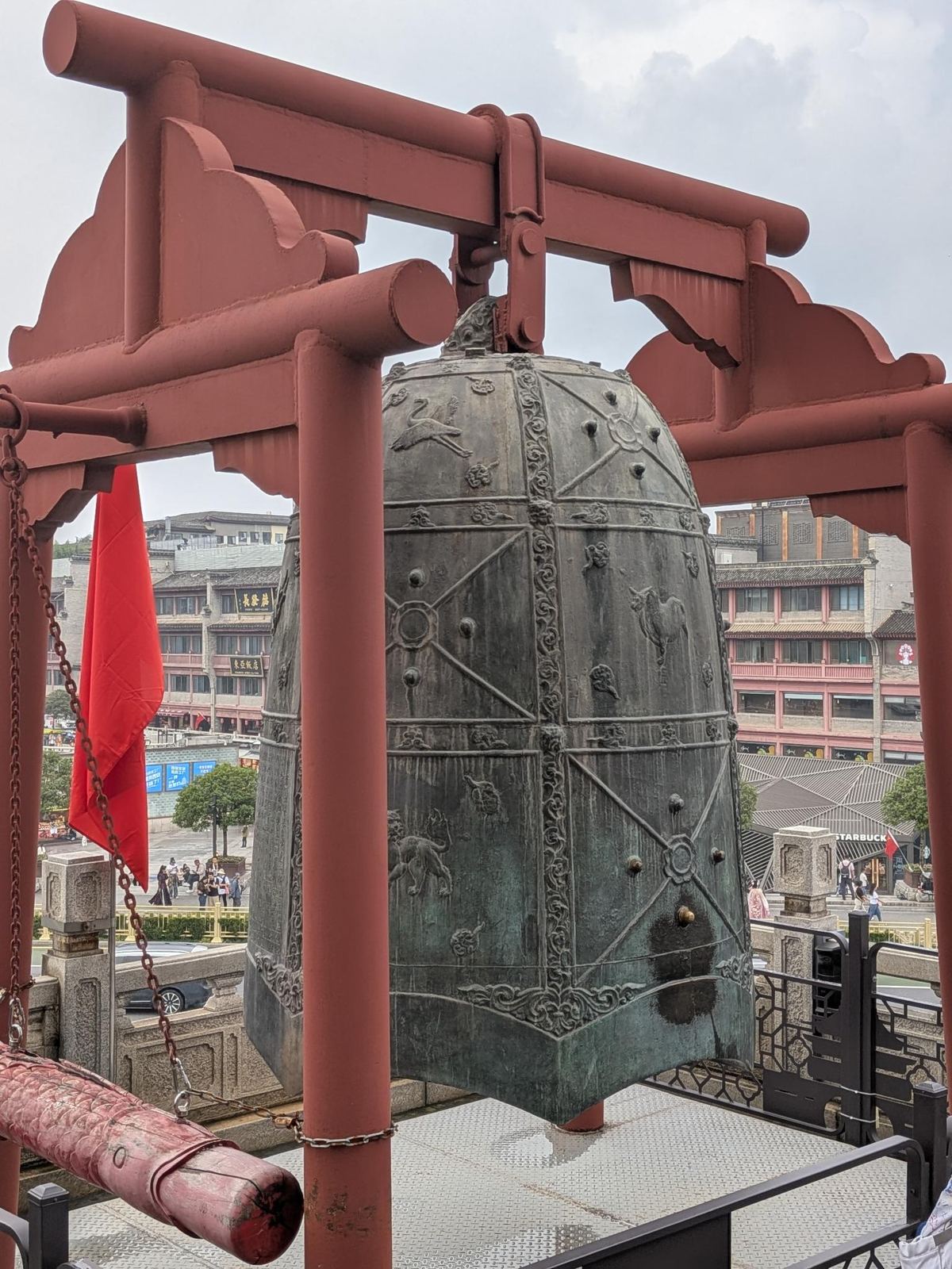 La grande cloche en bronze de Xi'an, ses panneaux sculptés d'animaux et de bosses, le marteau rouge à côté