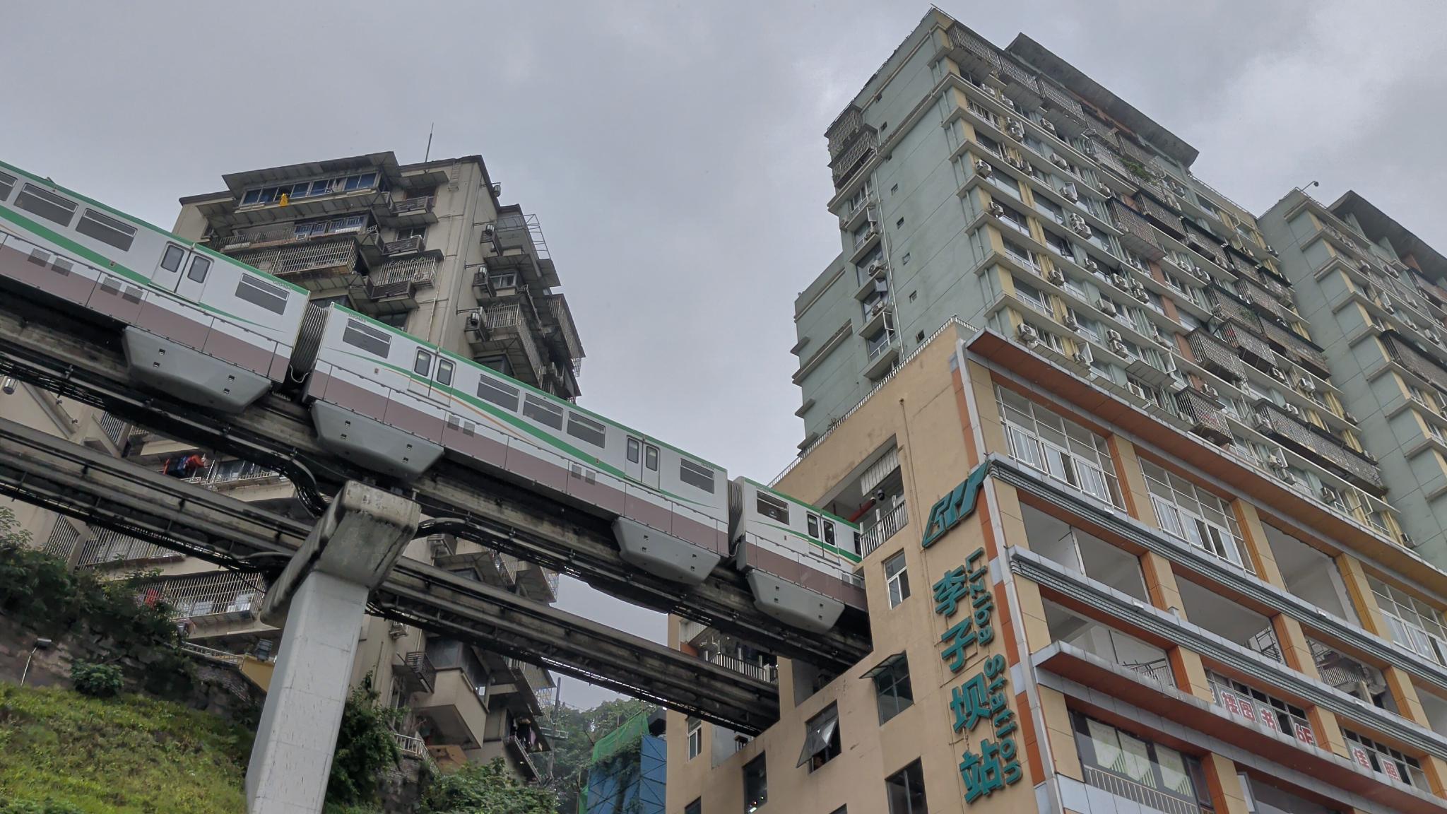 Le train dans le bâtiment, la station Liziba derrière
