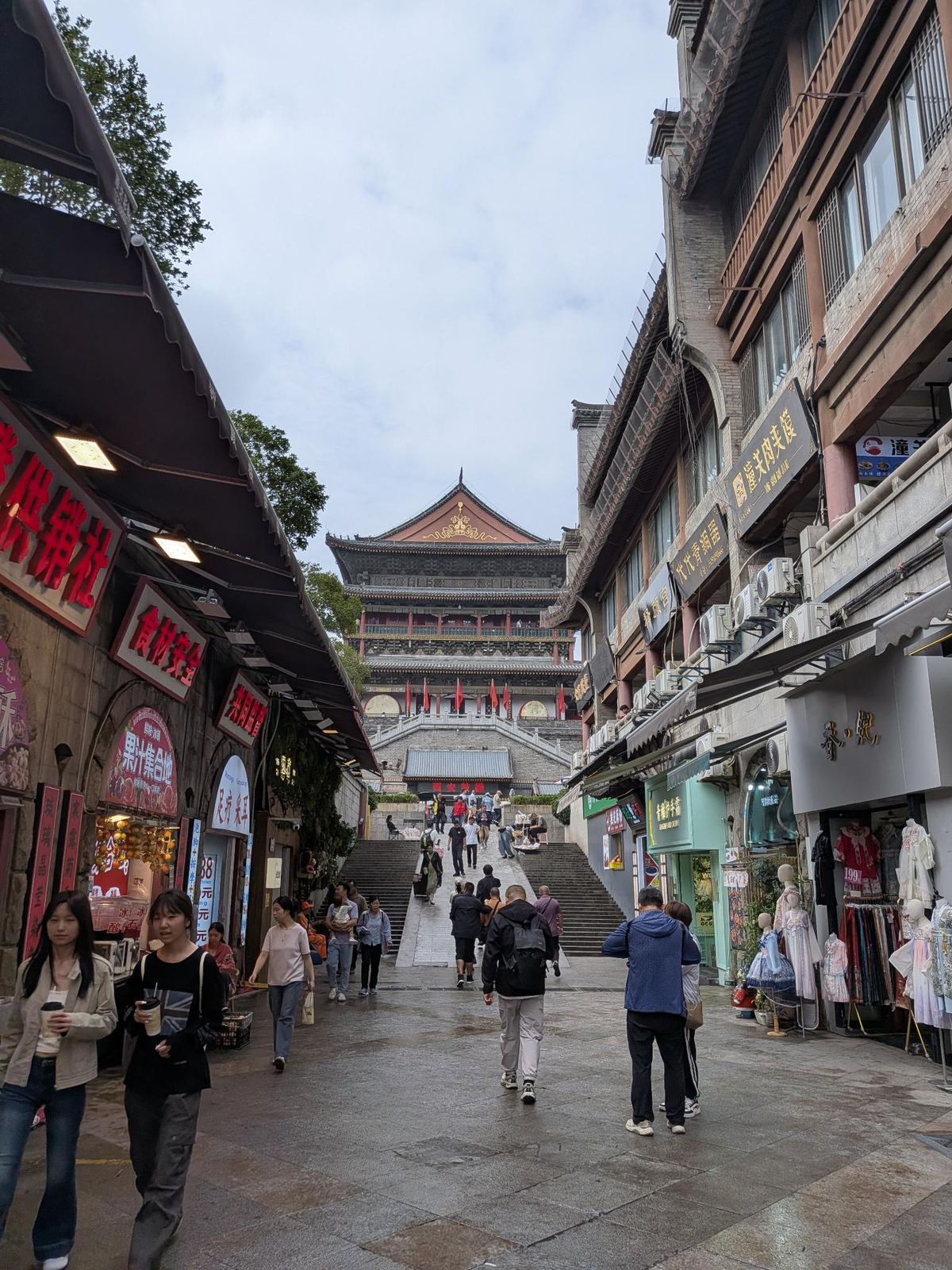 Rue Beiyuanmen avec ses échoppes au style Qing, enseigne 供销社, 潼关肉夹馍, 足疗采耳, tour de porte au loin