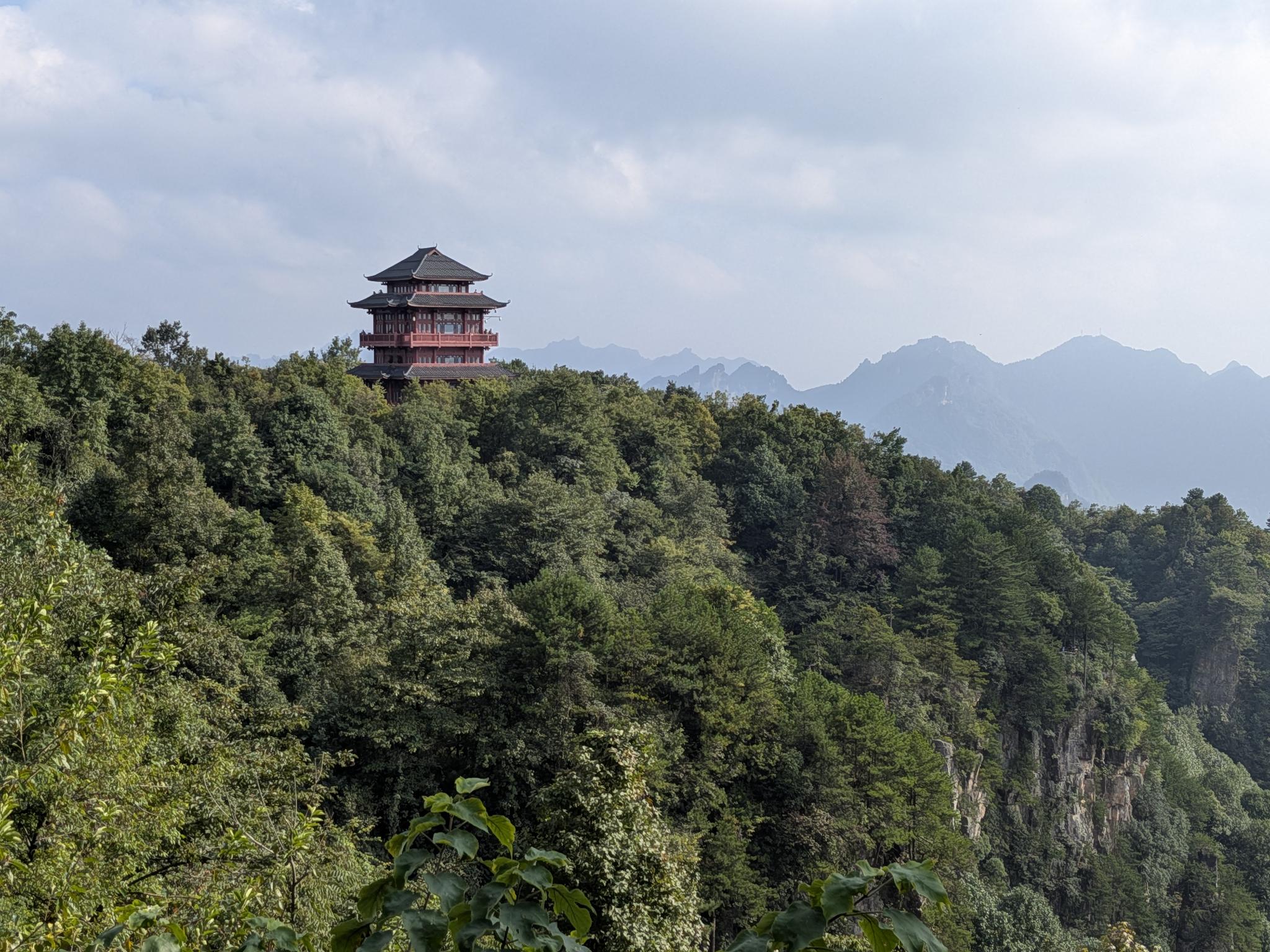 Le pavillon perché sur la colline boisée, les crêtes derrière