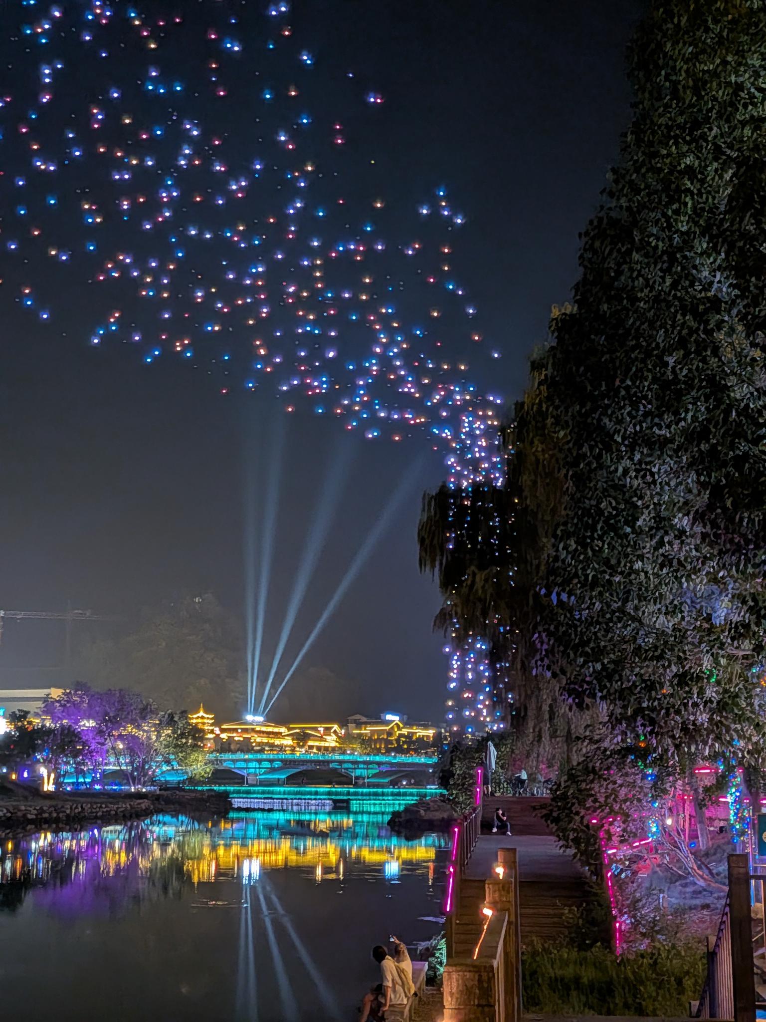 Les drones en vol, au-dessus du fleuve et du pont illuminé