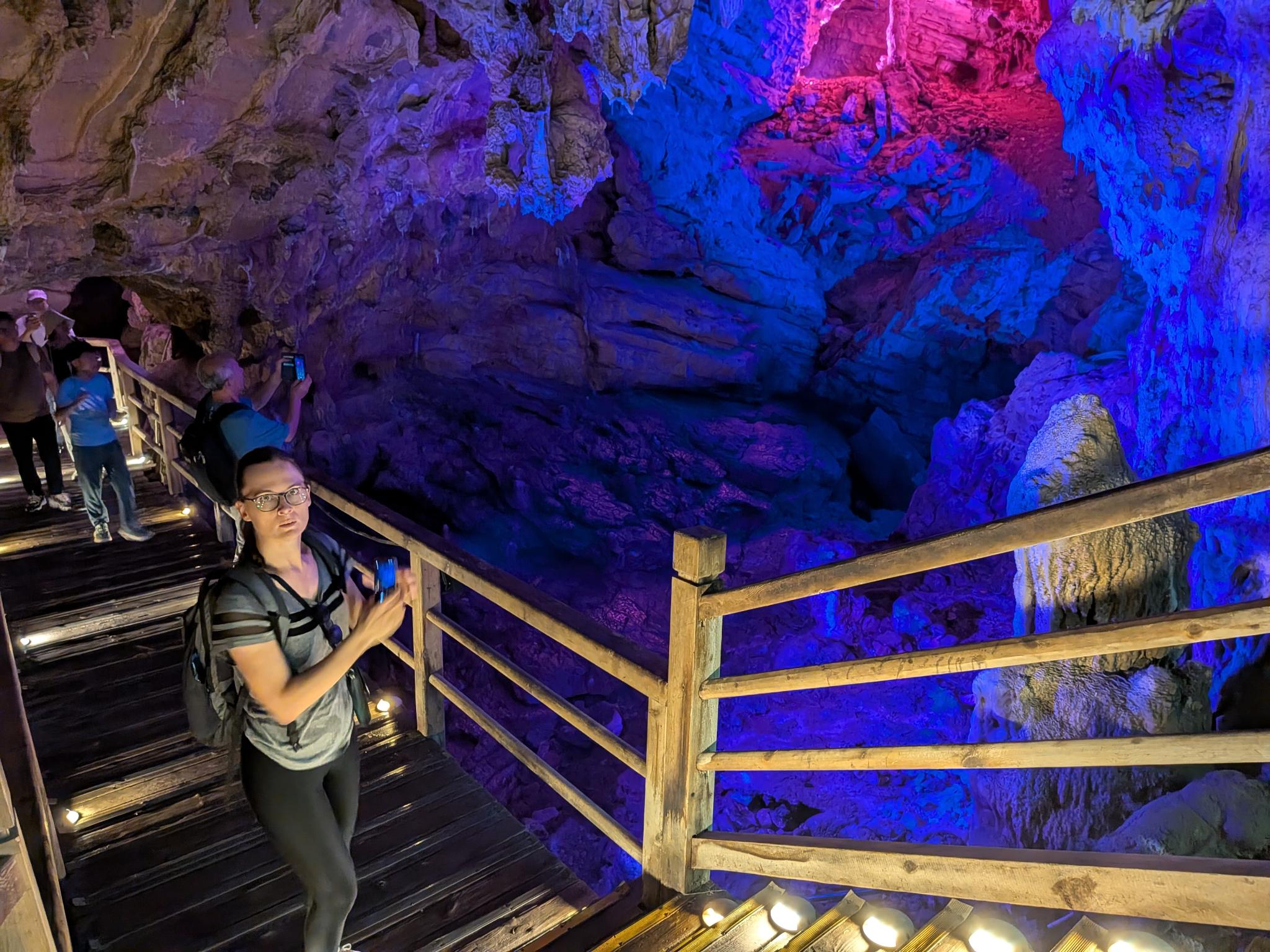 L'intérieur de la grotte, ses stalactites sous l'éclairage bleu, violet et rose