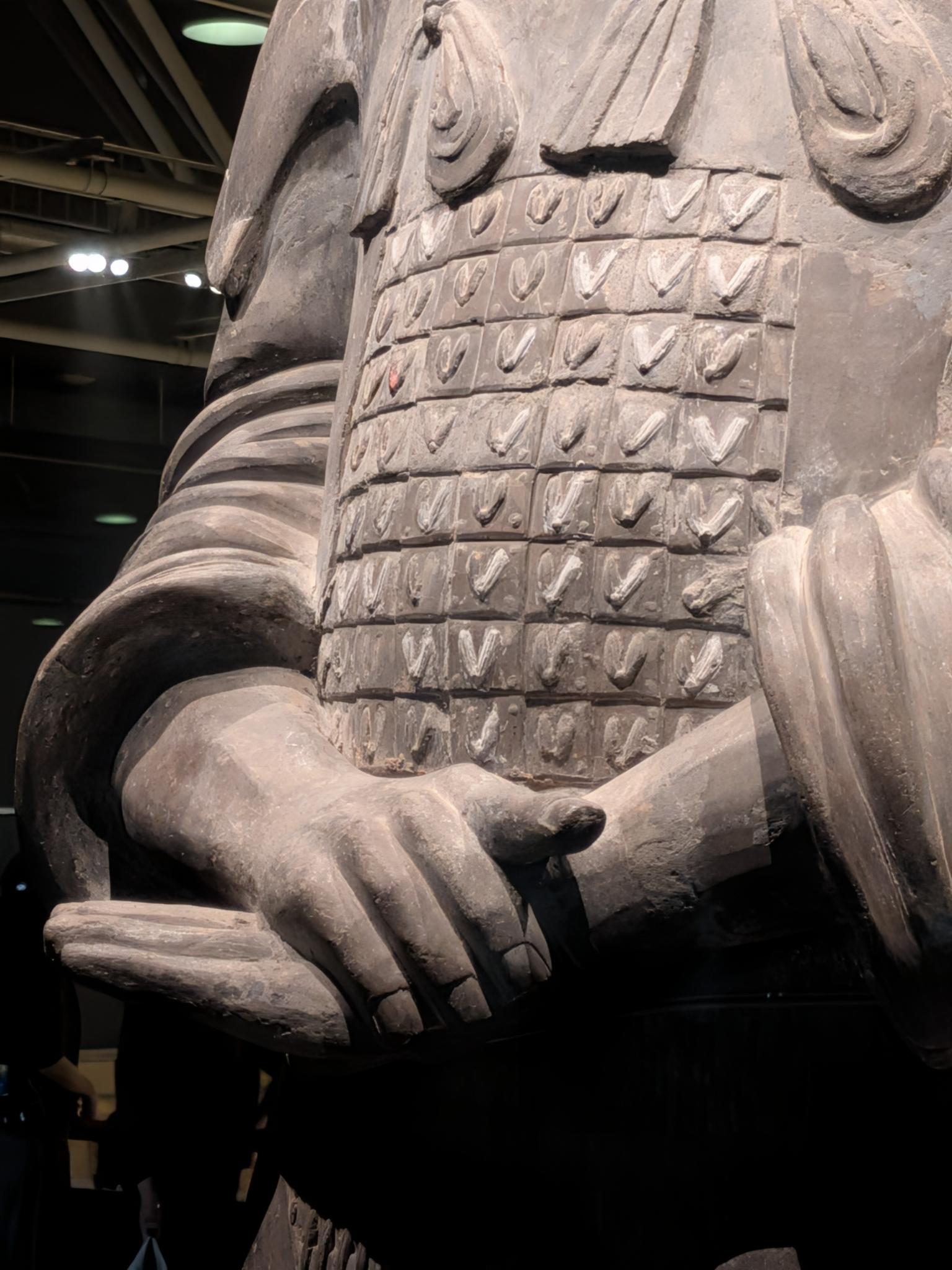 Torse d'un guerrier en armure segmentée, main sur le poignet de la ceinture