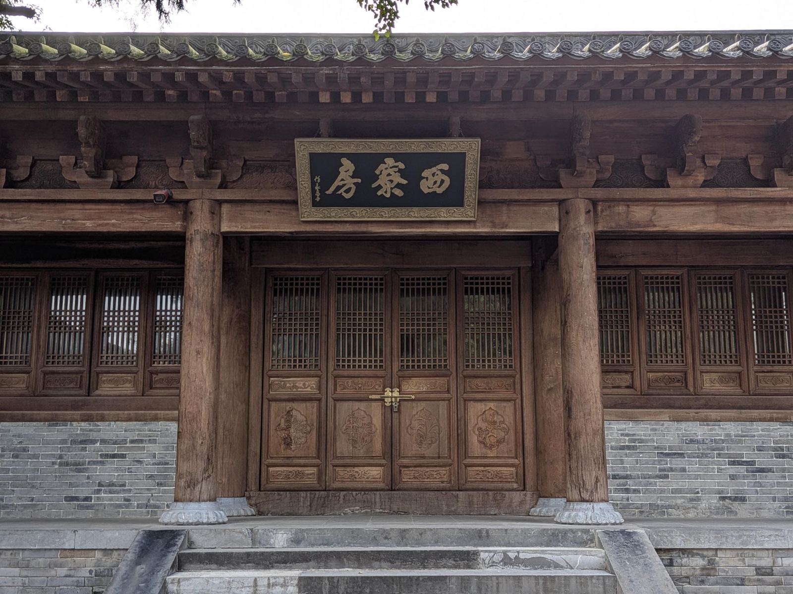 Façade de bois gris du 西寮房, portes à loquet de laiton, colonnes rondes sur socles sculptés, marches de pierre et murs en brique
