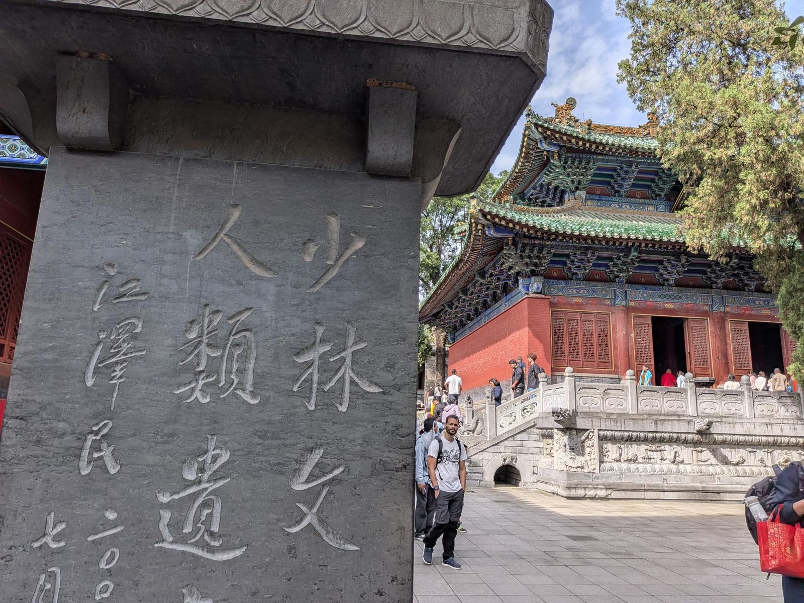 Stèle gravée 少林文化人類遺… signée 江澤民, hall du temple à toits verts et balustrade en arrière-plan, touristes qui flânent