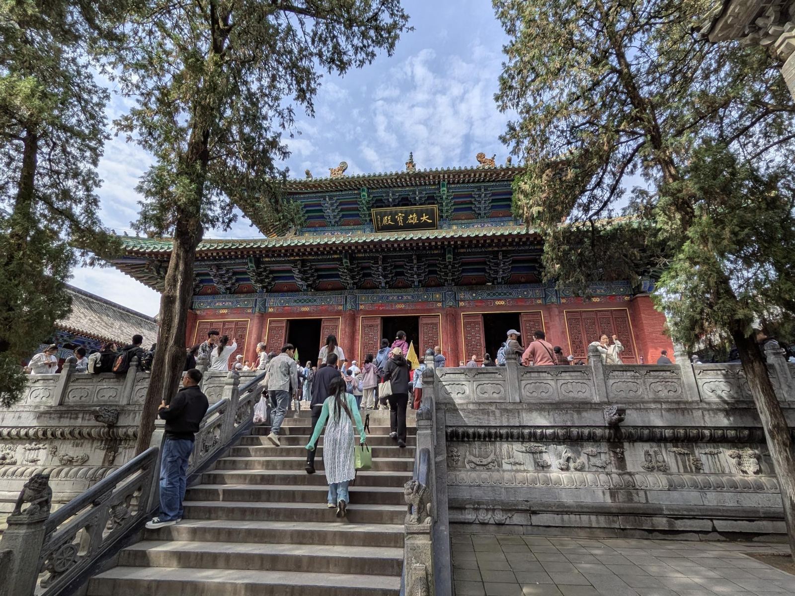 Le grand hall du Bouddha 大雄宝殿, murs rouges et toits verts, touristes sur les escaliers, cyprès de chaque côté