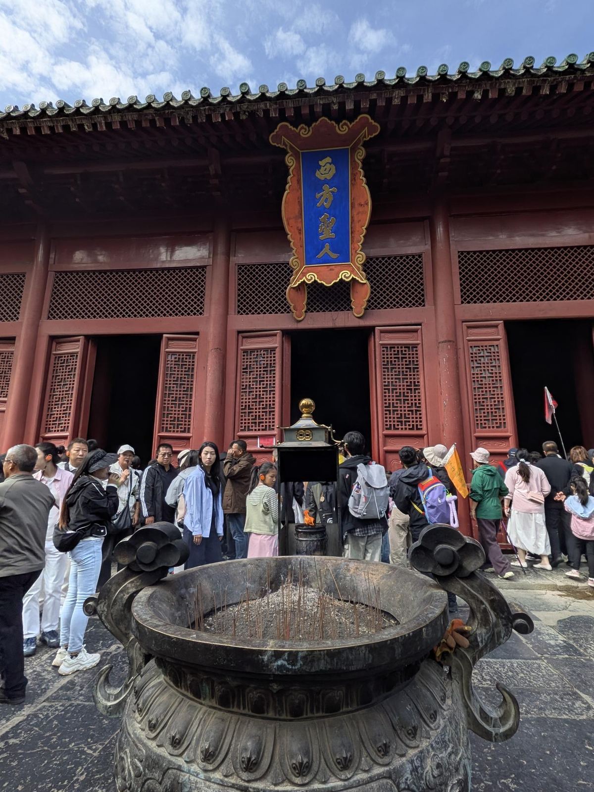 Façade du hall au fronton 西方聖人, grandes grille de fenêtres, encensoir en bronze rempli de cendres et de bâtonnets, foule devant les portes